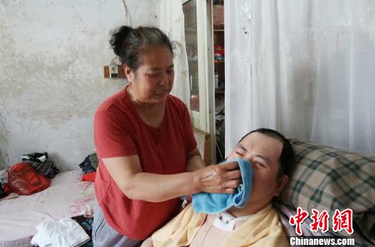 每次喂完食物后，梁青蘭都要仔細(xì)地幫兒子清理干凈。　尚明俠 攝