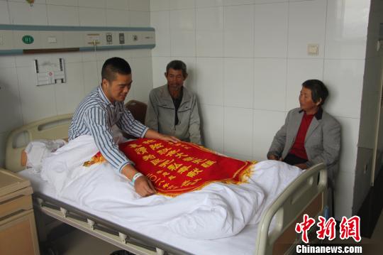 被救的李忠起、張總鳳夫婦看望受傷后的李運(yùn)飛?！⊥粲?攝