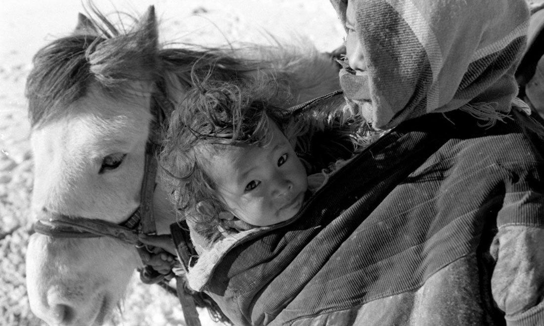 1990年3月，西藏當(dāng)雄縣納木湖鄉(xiāng)三村女牧民斯卓不畏嚴(yán)寒，懷抱幼子，準(zhǔn)備到遠(yuǎn)處放牧。新華社記者覺(jué)果攝