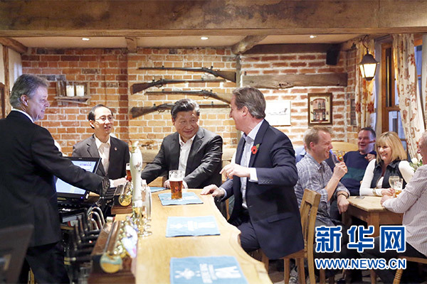 這是會晤結(jié)束后，習(xí)近平在卡梅倫陪同下乘車前往當(dāng)?shù)匦℃?zhèn)體驗酒吧文化。新華社記者 鞠鵬 攝